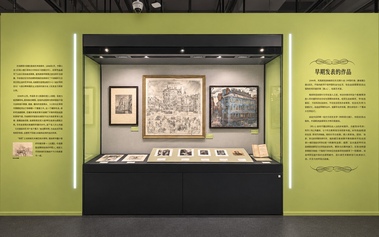 Installation view of “Dostoevsky’s World: To Stop Reading Is to Stop Thinking” at the China Press and Publications Museum, showing a glass display case with framed illustrations, prints, books, and Chinese wall text about Dostoevsky’s early published works.
