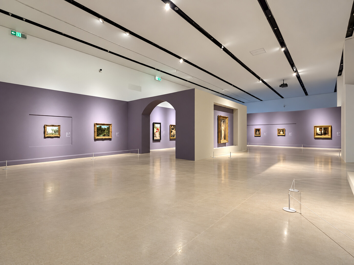 “大师之境”在深圳国际美术博物馆的展厅现场，宽敞展厅内为淡紫色墙面，墙上陈列多件欧洲绘画，天花设轨道灯，展区以低矮围绳分隔。